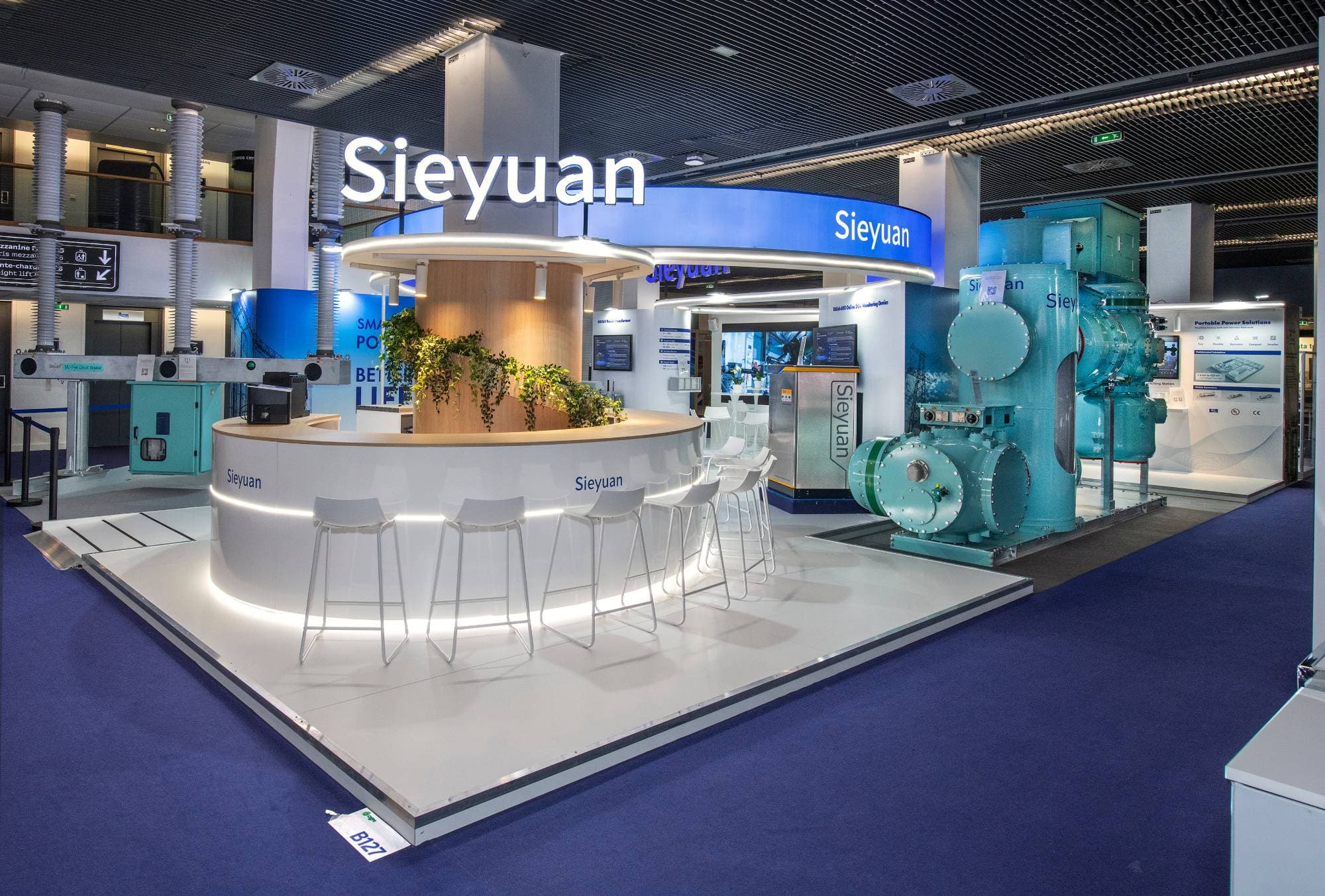 Stand Sieyuan : bar circulaire, enseigne lumineuse suspendue et plateforme d'exposition des appareillages
